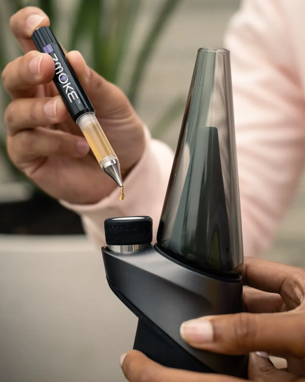 A ZMOKE applicator dispensing concentrate into a rig