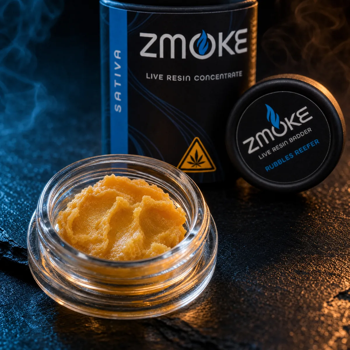 Open jar of golden ZMOKE live resin badder with its packaging on dark slate